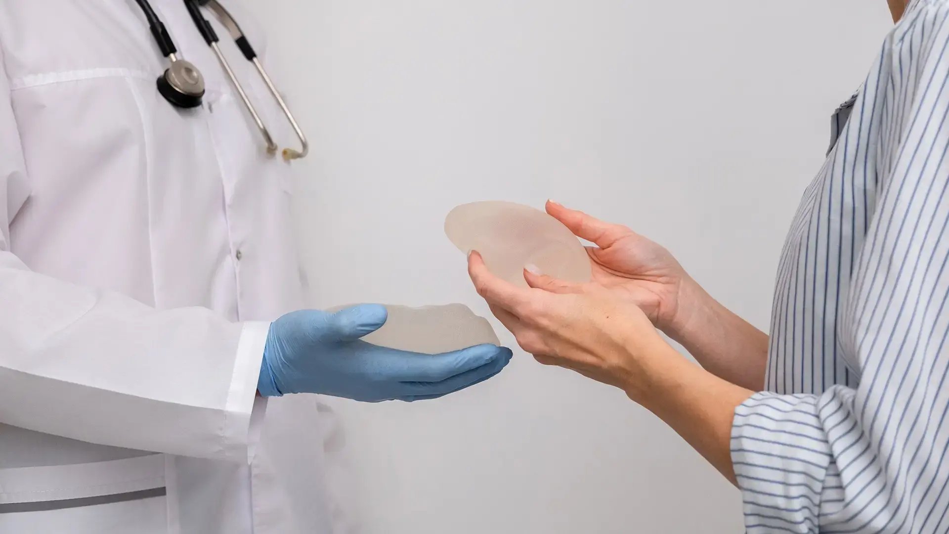 doctor-and-patient-exam-consultation-in-clinic-office-holding-breast-enlargement-implant-in-hands-plastic-surgery-beauty-enhancement-medical-Mammoplasty-and-plastic-surgery-mastopexy
